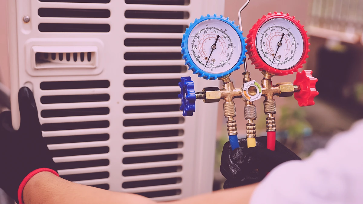 HVAC technician performing maintenance on a home air conditioning system