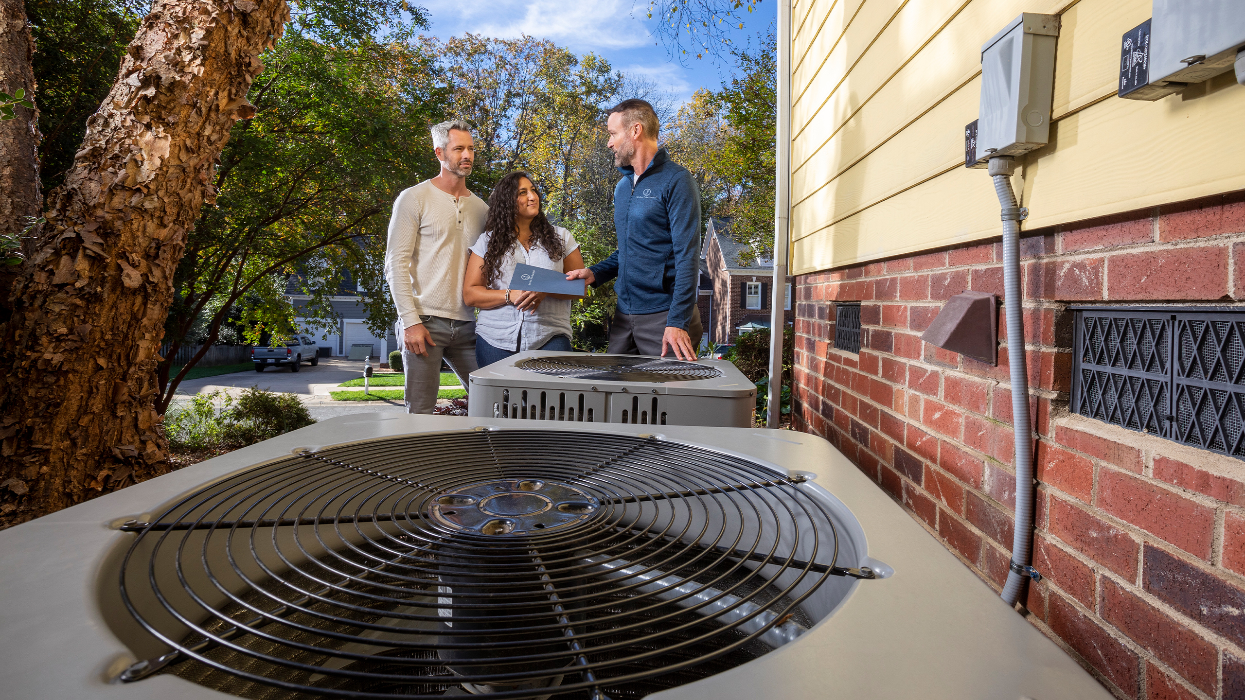 HVAC technician discussing an air conditioning system with homeowners